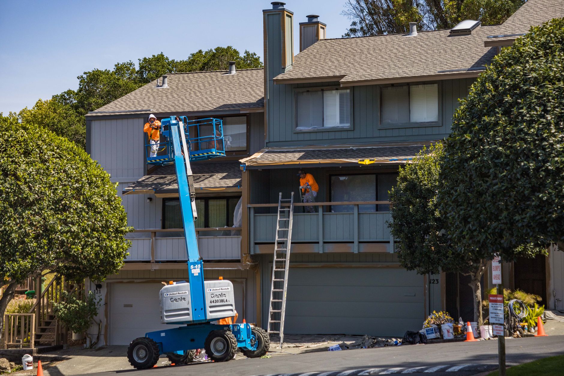 Painters on a lift renovating a home exterior