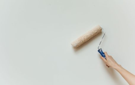 Hand repainting an interior wall with a roller