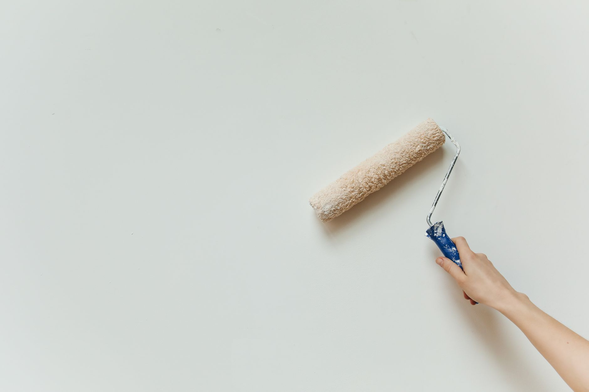 Hand repainting an interior wall with a roller